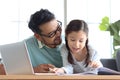 Father teaches cute girl daughter to do school homework, using laptop computer for e-learning study at home, happy family dad and Royalty Free Stock Photo