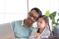 Father teaches cute girl daughter to do school homework, using laptop computer for e-learning study at home, happy family dad and Royalty Free Stock Photo