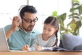 Father teaches cute girl daughter to do school homework, using laptop computer for e-learning study at home, happy family dad and Royalty Free Stock Photo