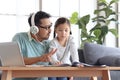 Father teaches cute girl daughter to do school homework, using laptop computer for e-learning study at home, happy family dad and Royalty Free Stock Photo