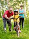 Father teaches his daughter to ride a bike