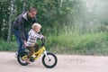 Father teaches his little child to ride bike in spring summer park. Happy family moments. Time together dad and son. Candid Royalty Free Stock Photo