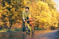 Father teaches his little kid to ride bike in autumn park. Child practicing cycling. Happy family moments. Time together dad and Royalty Free Stock Photo