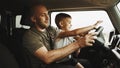Father teaches little son to drive on road trip Royalty Free Stock Photo