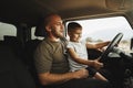 Father teaches little son to drive on road trip Royalty Free Stock Photo