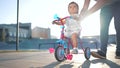 father teaches son baby to ride a children bike. happy family kid dream concept. baby baby rides a bike dad helps Royalty Free Stock Photo