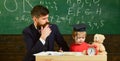 Father teaches son, discuss, explain. Kid studying with teacher. Elementary education. Teacher in formal wear and pupil