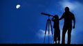 Father teaches son to look at the moon with the telescope