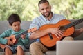 Father teaching child guitar, learning music skill in brazil home and happy singing together. Acoustic musical