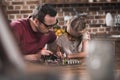 Father teaching daughter to braze at the kitchen table