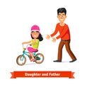 Father teaching daughter to ride a bicycle