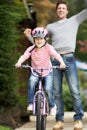 Father Teaching Daughter To Ride Bike In Garden Royalty Free Stock Photo