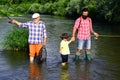Father teaching his son fishing against view of river and landscape. Generations men. Father, son and grandfather on Royalty Free Stock Photo