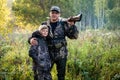 Father teaching his son about gun safety and proper use on hunting in nature. Royalty Free Stock Photo