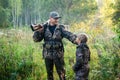 Father teaching his son about gun safety and proper use on hunting in nature. Royalty Free Stock Photo