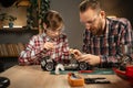 Father teaching his son for soldering remote controlled car in the evening at home. Man and boy fixing broken toy. Royalty Free Stock Photo