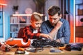 Father teaching his son to repair red toy car Royalty Free Stock Photo