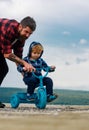 Father teaching his son to ride a bicycle. Little boy learn to ride a bike with his daddy. Dad teaching son to ride