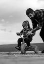 Father teaching his son to ride a bicycle. Little boy learn to ride a bike with his daddy. Dad teaching son to ride