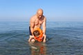 Father teaching his son to swim in sea