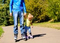 Father teaching little daugther to roller skate in summer