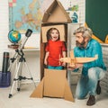 Father teaching son. Child in astronauts costumes with toy rocket playing and dreaming of becoming a spacemen. Astronomy Royalty Free Stock Photo