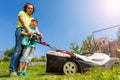 Father teaching son edging the lawn with lawnmower