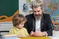 Father teaching son. Funny little child with father having fun on blackboard background. Supporting pupils at school Royalty Free Stock Photo