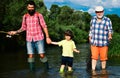 Father teaching son how to fly-fish in river. Little boy fly fishing on a lake with his father and grandfather. Royalty Free Stock Photo
