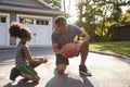 Father Teaching Son How To Play Basketball On Driveway At Home Royalty Free Stock Photo