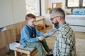 Father teaching son how to tie a tie. Memorable moment for young boy.