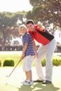 Father Teaching Son To Play Golf