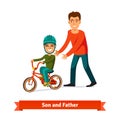 Father teaching son to ride a bicycle