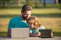 Father teaching son to use laptop, dad and school boy child looking computer screen and tablet, playing game, watching Royalty Free Stock Photo