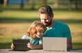 Father teaching son to use laptop, dad and school boy child looking computer screen and tablet, playing game, watching Royalty Free Stock Photo