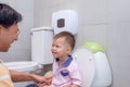 Father teaching son to use public toilet for kids in family restroom