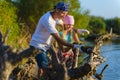 Father and Teen girl with sabersaw is sawing a logs