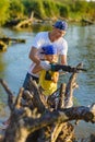 Father and Teen girl with sabersaw is sawing a logs