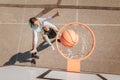 Father and teenage daughter playing basketball outside at court, high angle view above hoop net.