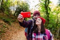 Father and teenage daughter taking a selfie in the forest in autumn