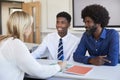 Father And Teenage Son Having Discussion With Female Teacher At High School Parents Evening