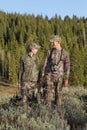 Father and son bow hunting together in woods Royalty Free Stock Photo