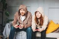 Father and teenager daughter tween girl in hoodies playing computer games with joystick at home tipical caucasian family Royalty Free Stock Photo