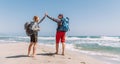 Father and teenager son with backpacks making High FIVE on sandy seaside beach during Lycian Way trekking walk. Famous Likya Yolu Royalty Free Stock Photo