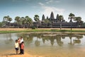 Father with three kids standing past historical landscape of Angkor What temple, 12th century Khmer landmark