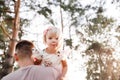 Father throws baby in nature, girl flies in the sky. Portrait dad with child together. Daddy, little daughter outdoors