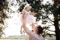 Father throws baby in nature, girl flies in the sky. Portrait dad with child together. Daddy, little daughter outdoors