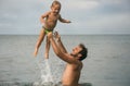 Father throws small son over water