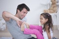 Father tickling daughter's foot at home