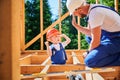 Father teaching his toddler son the art building wooden frame house on construction site. Royalty Free Stock Photo